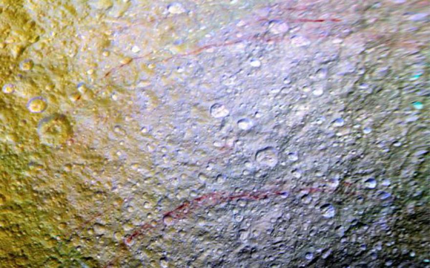 На поверхности спутника Сатурна обнаружили непонятные красные дуги
